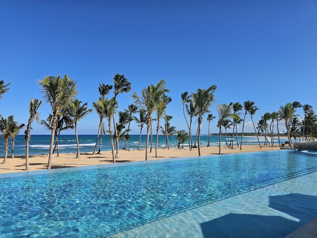 Main oceanfront pool at W Punta Cana with loungers, umbrellas, and DJ entertainment