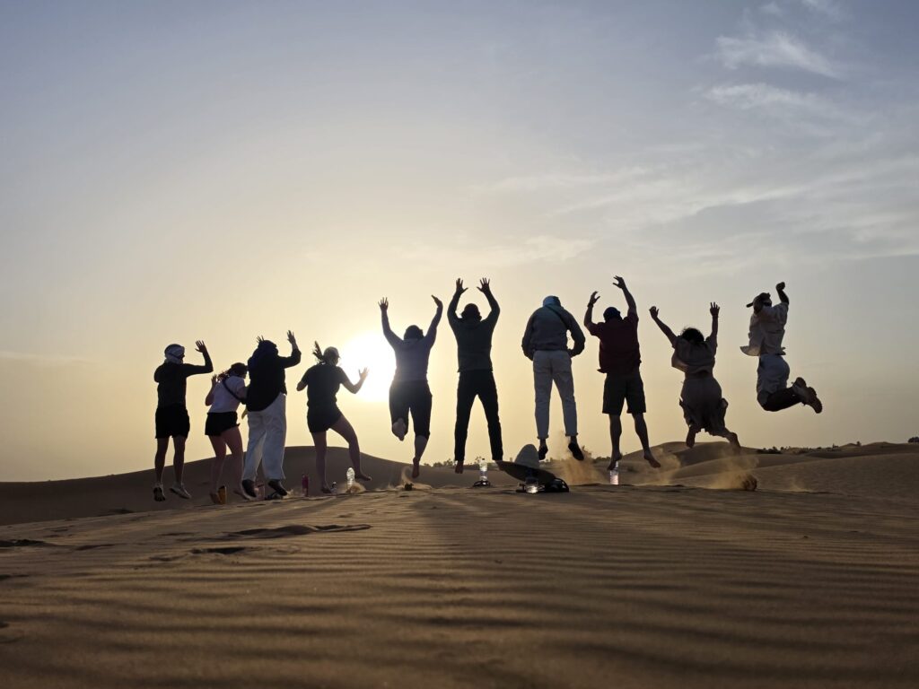 New friends jumping in the Sahara Desert in Morocco